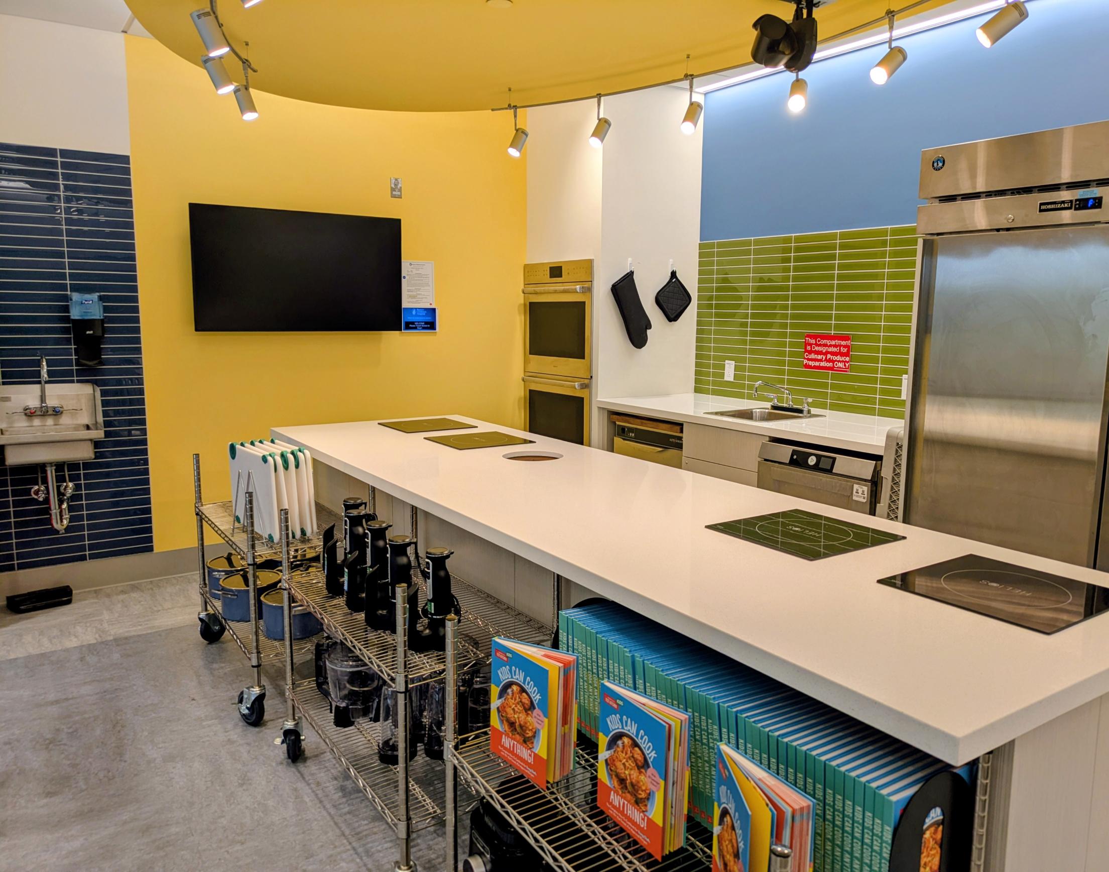 Image of large kitchen with island, sink, oven, and other kitchen appliances