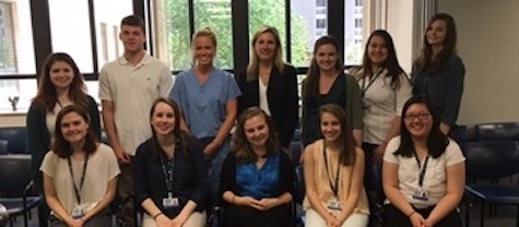 twelve men and women standing and sitting