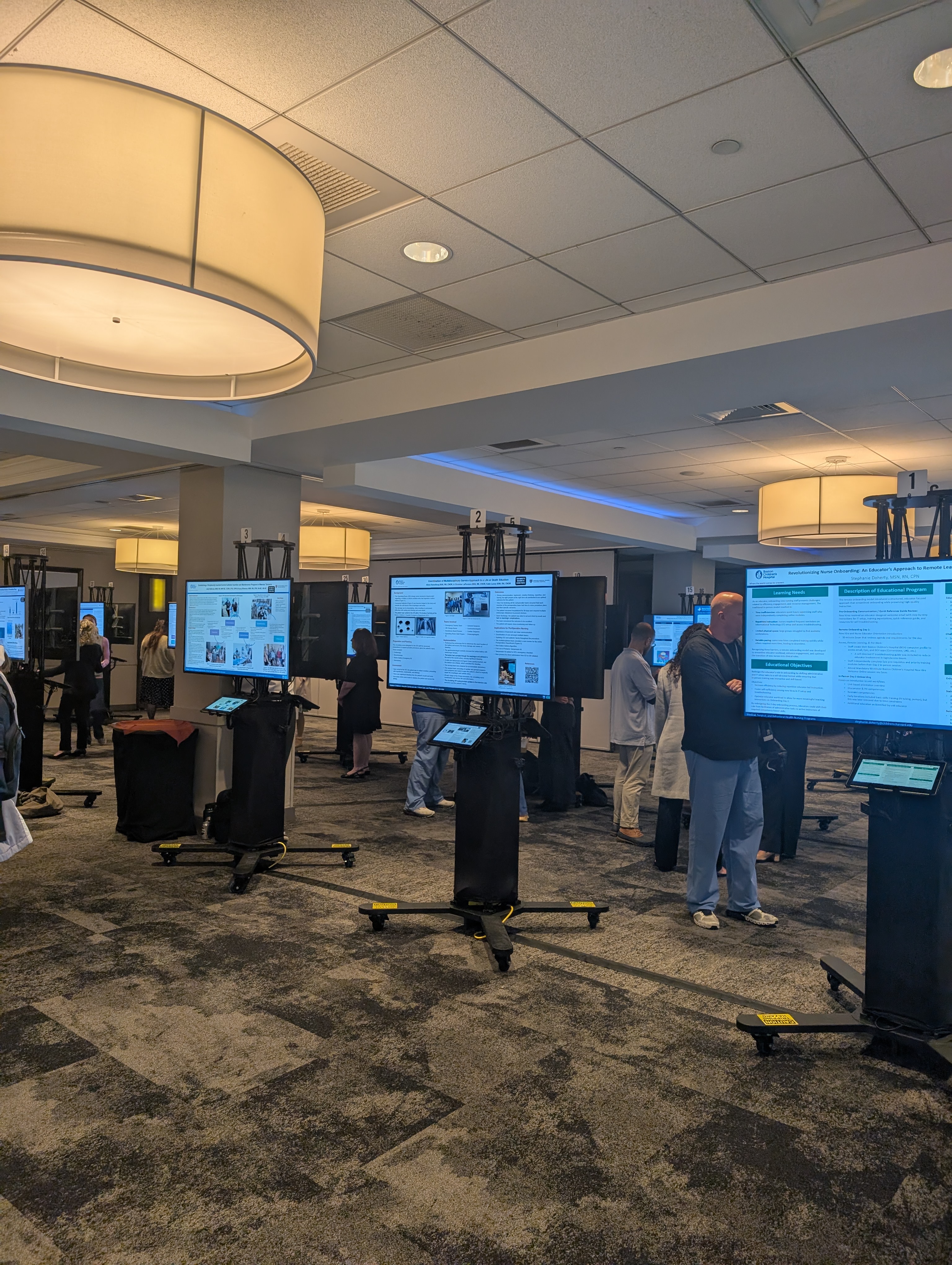 A row of presentation screens in a conference hall.