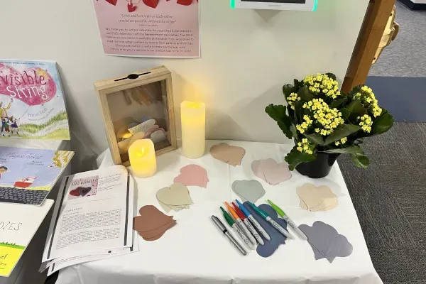 Table with markers for drawing and two lit candles