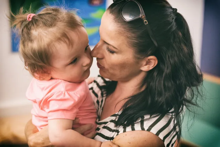 Mom holds young girl