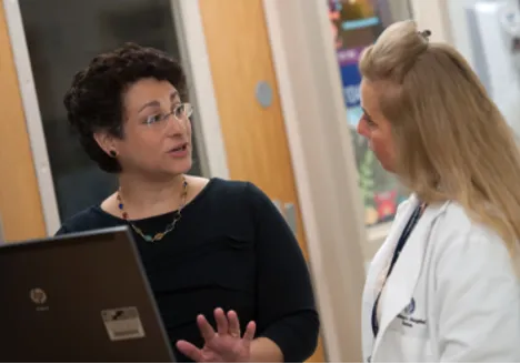 Two woman are talking together face to face.