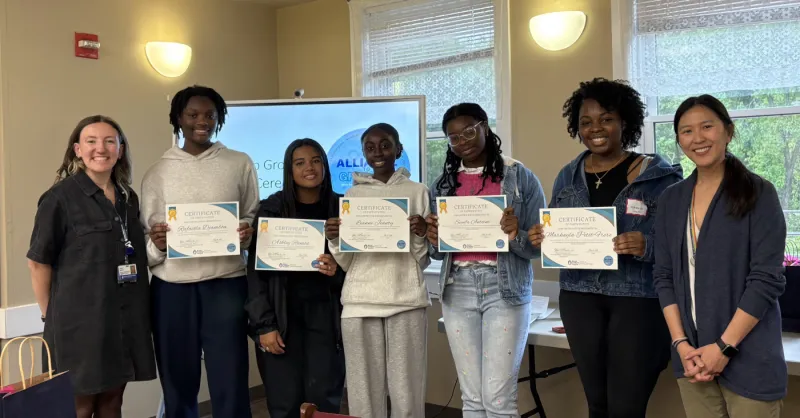 Conference attendees pose for photo, with some holding certificates