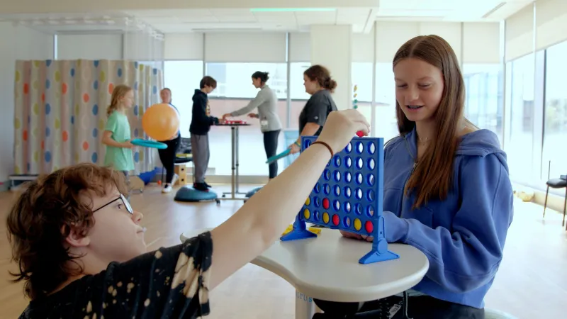Boy and girl, patients at Pediatric Pain Rehabilitation Center (PPRC), play Connect Four.